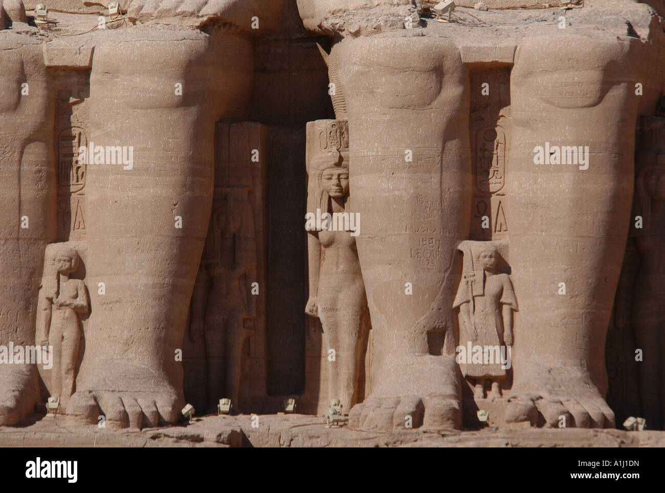 Huge legs of the colossi of pharaoh Ramesses II in front of the Sun Temple of Abu Simbel near Aswan, Egypt. Stock Photo