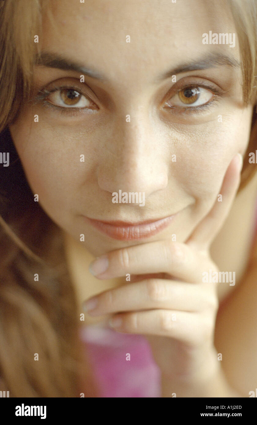 Attractive woman close up portrait with hand held against chin c Luke Peters Stock Photo
