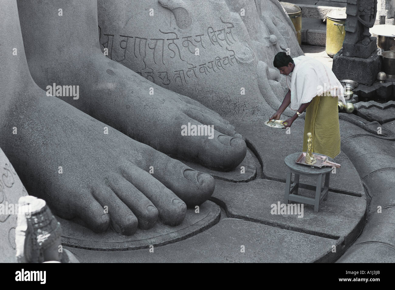 VDA76005 Priest performing prayers at feet of Bahubali statue Sravanbelgola Karnataka India Stock Photo