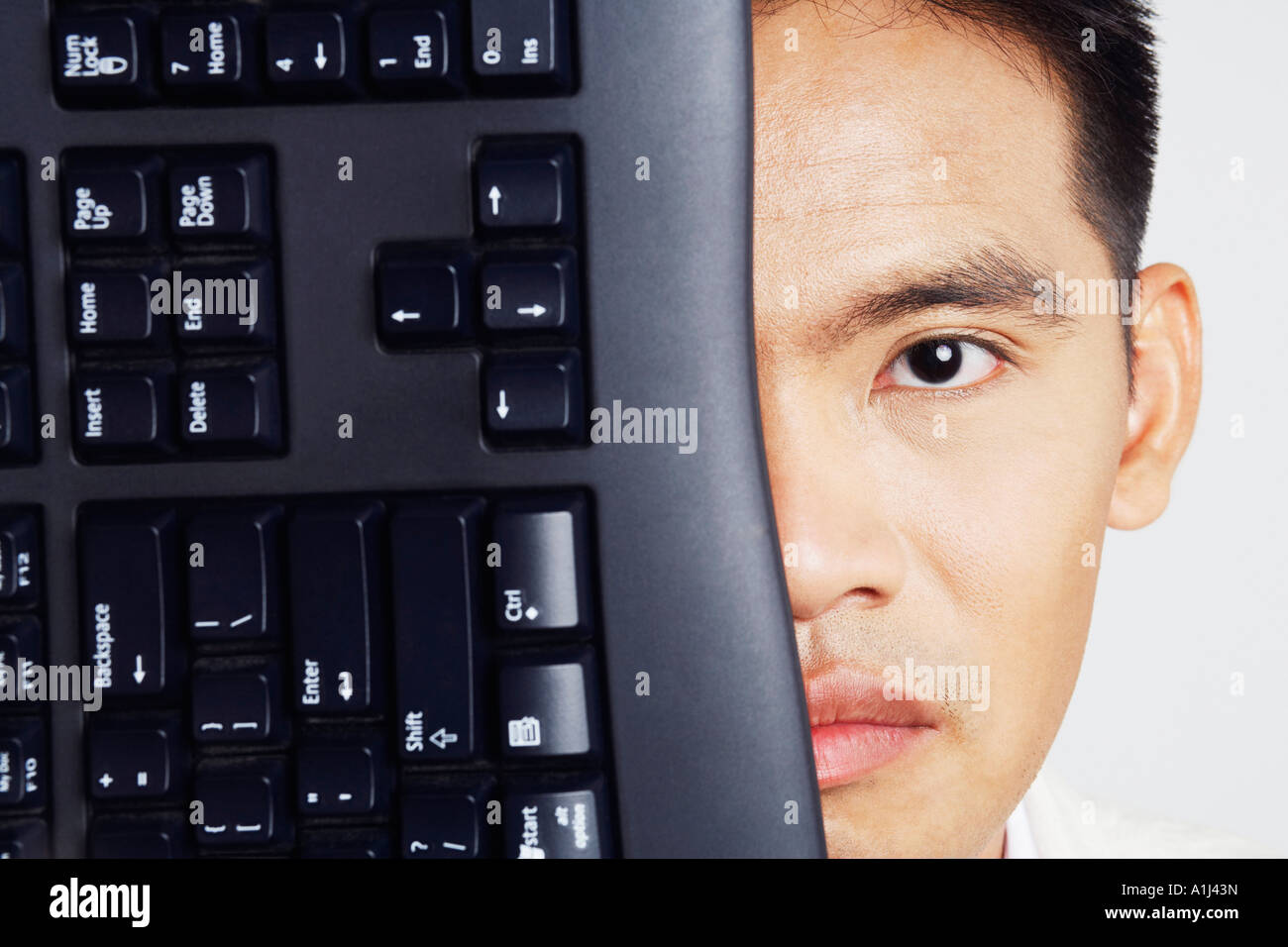 Portrait of a businessman with a computer keyboard in front of his face