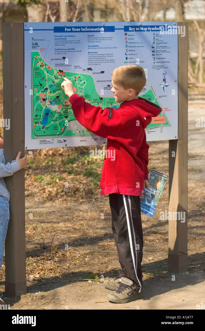 9 Nine year old boy student looks at a map at the Detroit Michigan Zoo Stock Photo