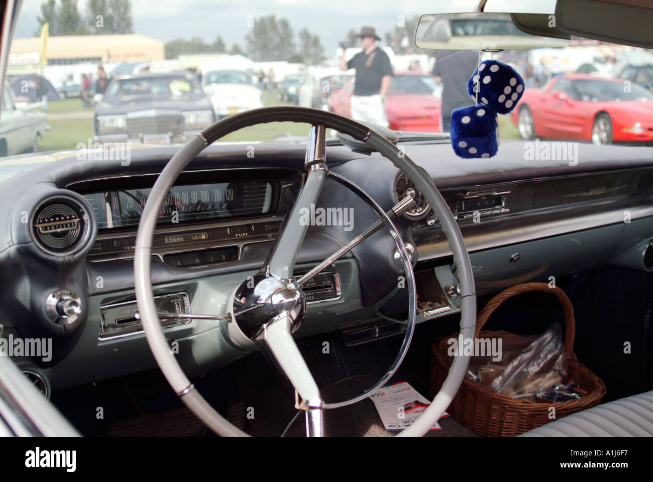 fuzzy dice hanging from rear view mirror in 1950 s american car large diameter steering wheel cruise happy days v8 engine luxury Stock Photo