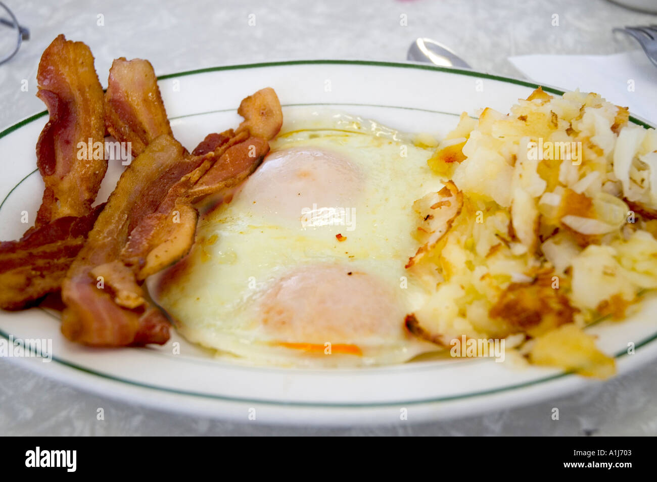 Breakfast plate with bacon eggs potatoes toast and coffee Stock Photo