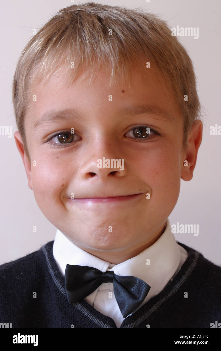 Young boy aged 8 years old wearing a bow tie white shirt and jumper