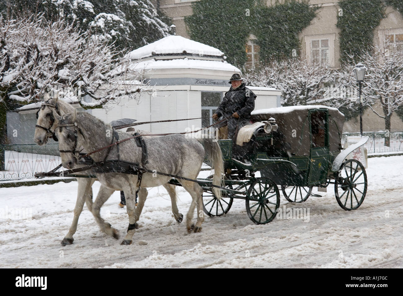 Horsedrawn carriage ride in a snowstorm, Old Town (Altstadt), Salzburg, Austria Stock Photo