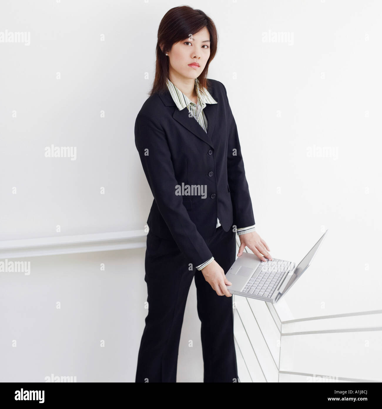 Portrait of a businesswoman holding a laptop and posing Stock Photo