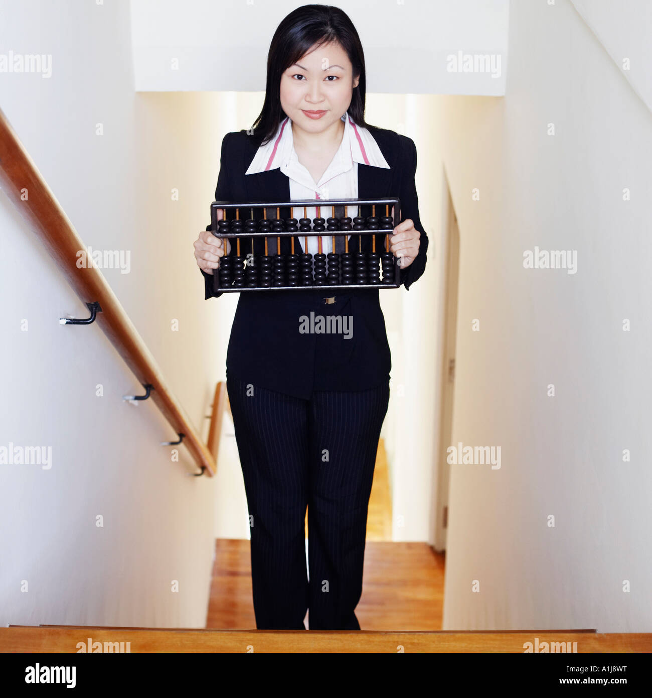 Portrait of a businesswoman holding an abacus and standing on the staircase Stock Photo
