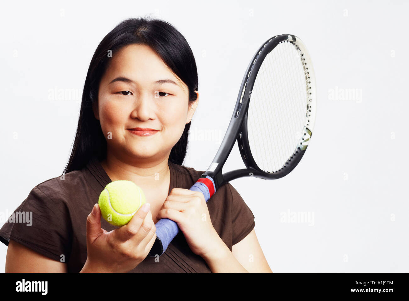 Portrait of a mid adult woman holding a tennis ball and a tennis racket