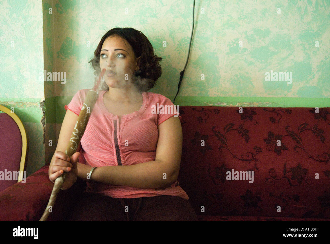 Abu Dhabi United Arab Emirates UAE. Female foreign worker from Ethopia smoking a traditional Shisha pipe HOMER SYKES Stock Photo