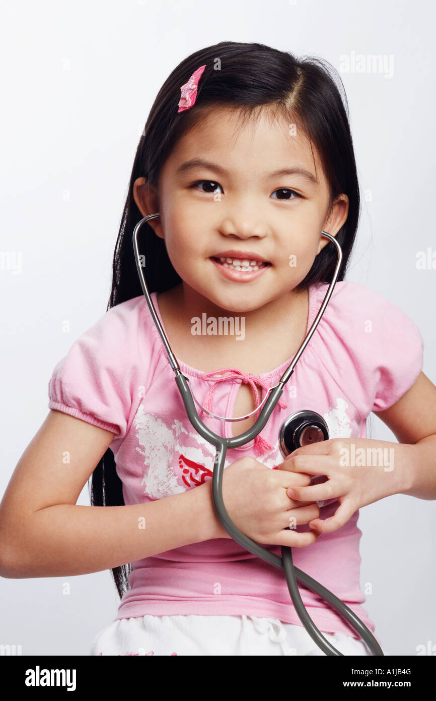 Portrait of a girl listening to her heart beat with a stethoscope Stock Photo