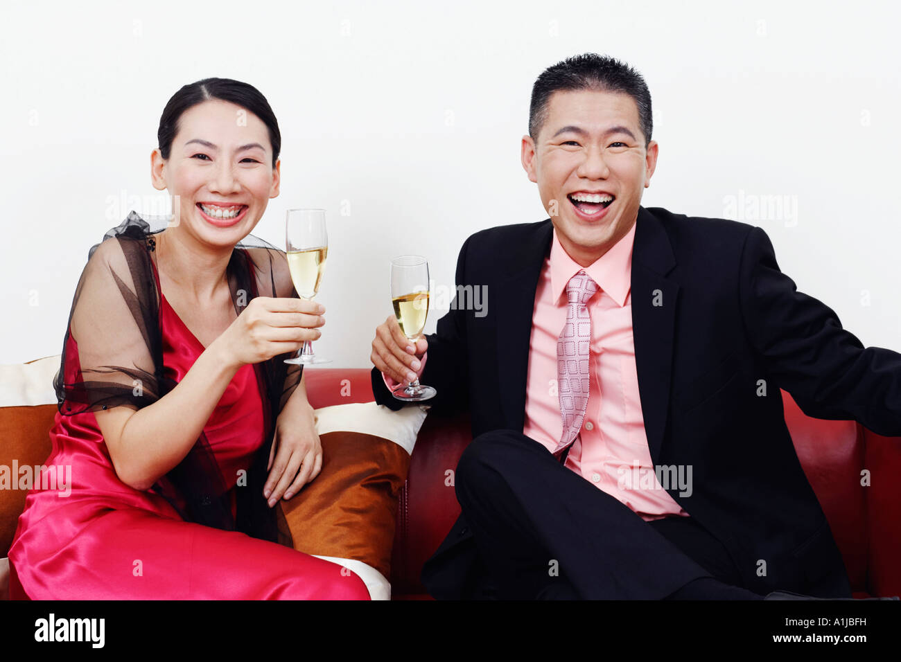 Portrait of a businessman and a mid adult woman holding glasses of champagne and laughing Stock Photo