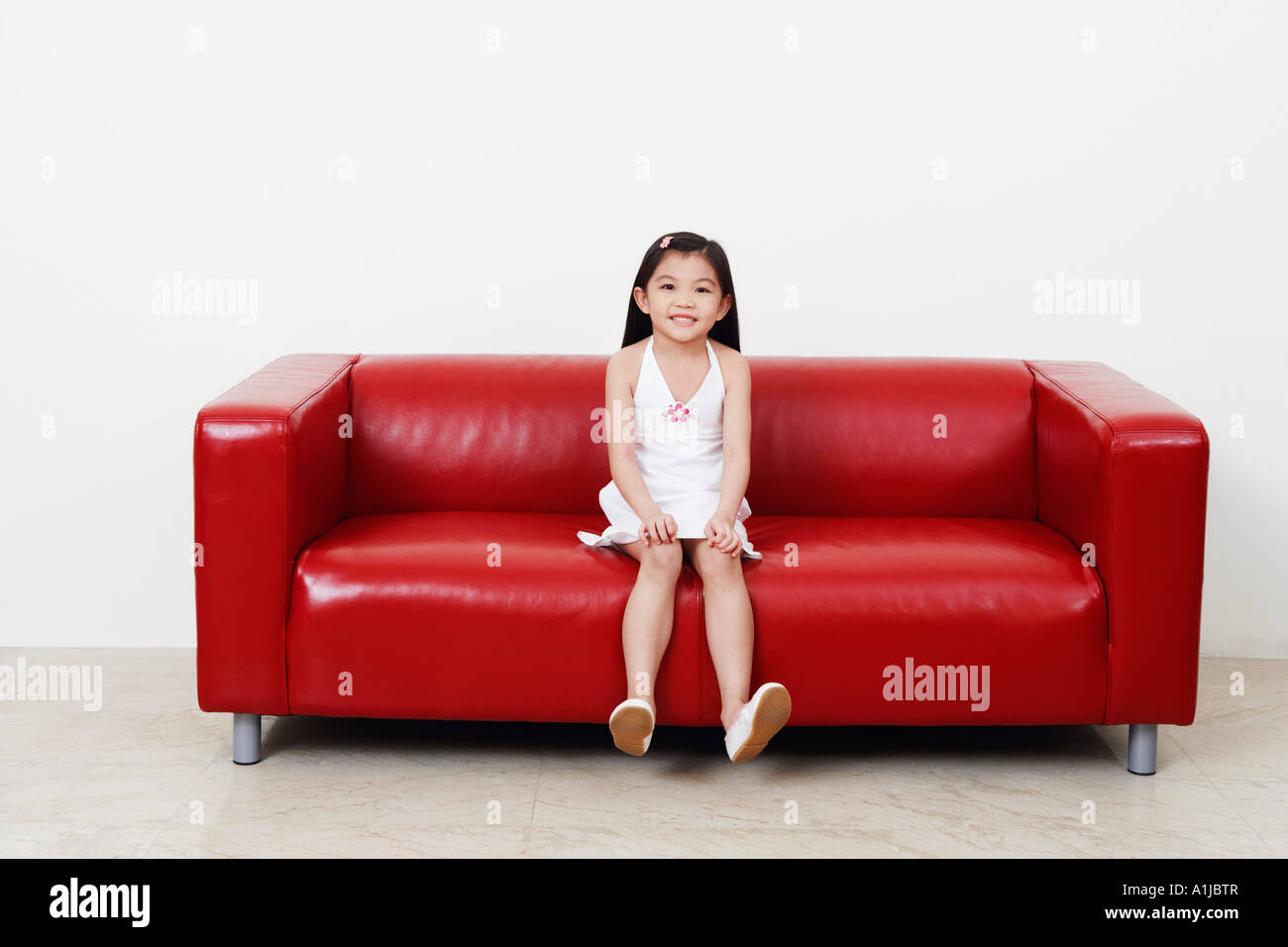 Portrait of a girl sitting on a couch Stock Photo - Alamy