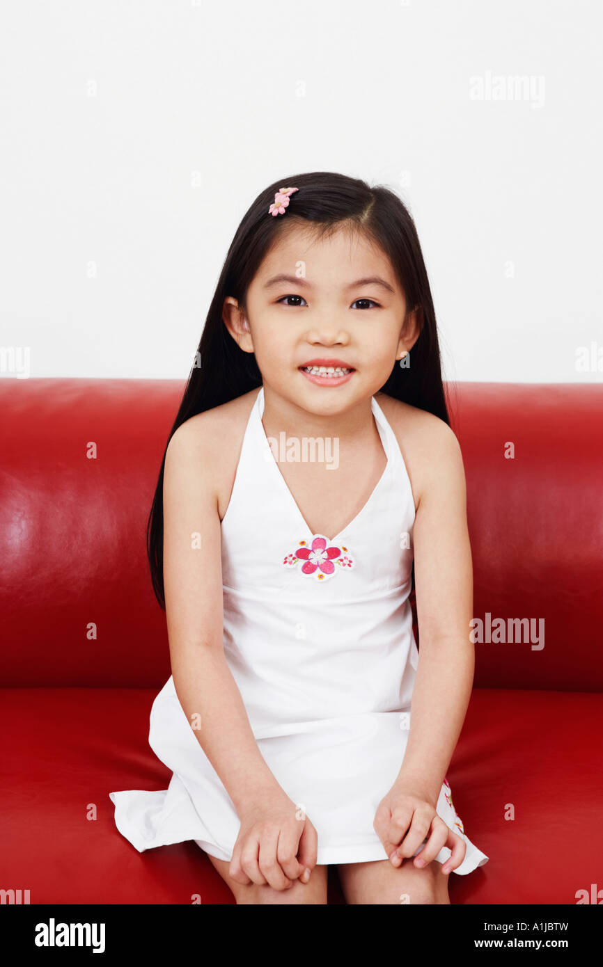 Portrait of a girl sitting on a couch Stock Photo - Alamy