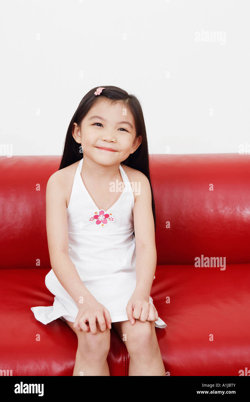 Portrait of a girl sitting on a couch Stock Photo - Alamy
