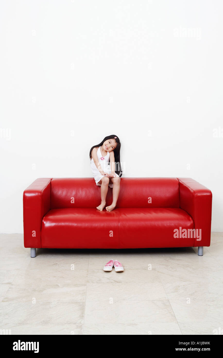 Portrait of a girl sitting on a couch Stock Photo - Alamy