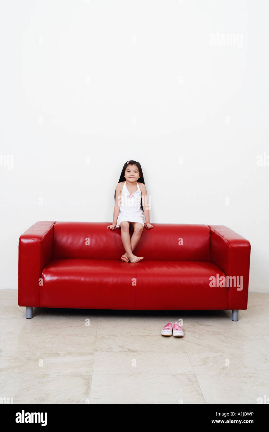 Portrait of a girl sitting on a couch Stock Photo - Alamy