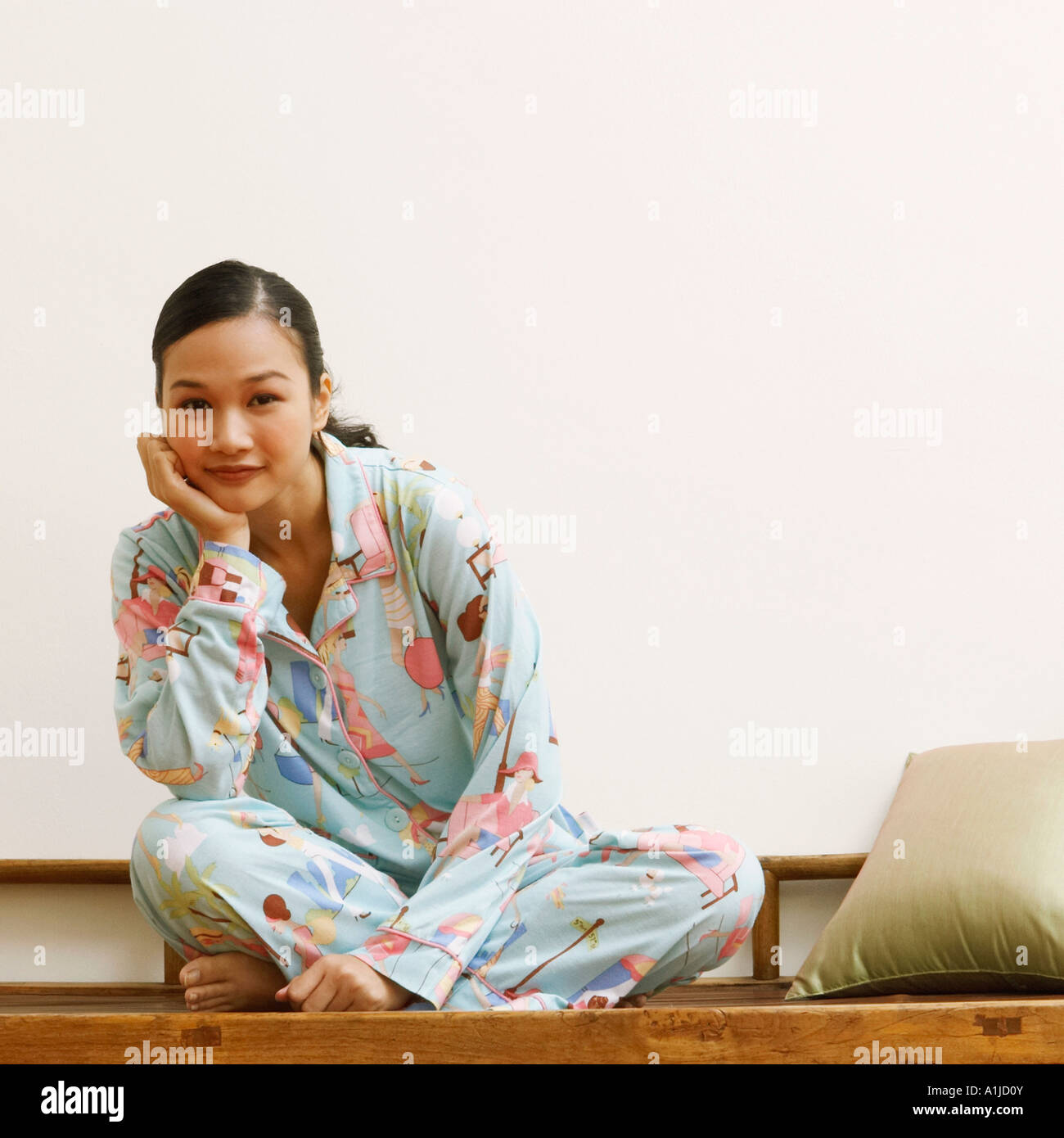Portrait of a young woman sitting on a bench and smiling Stock Photo ...