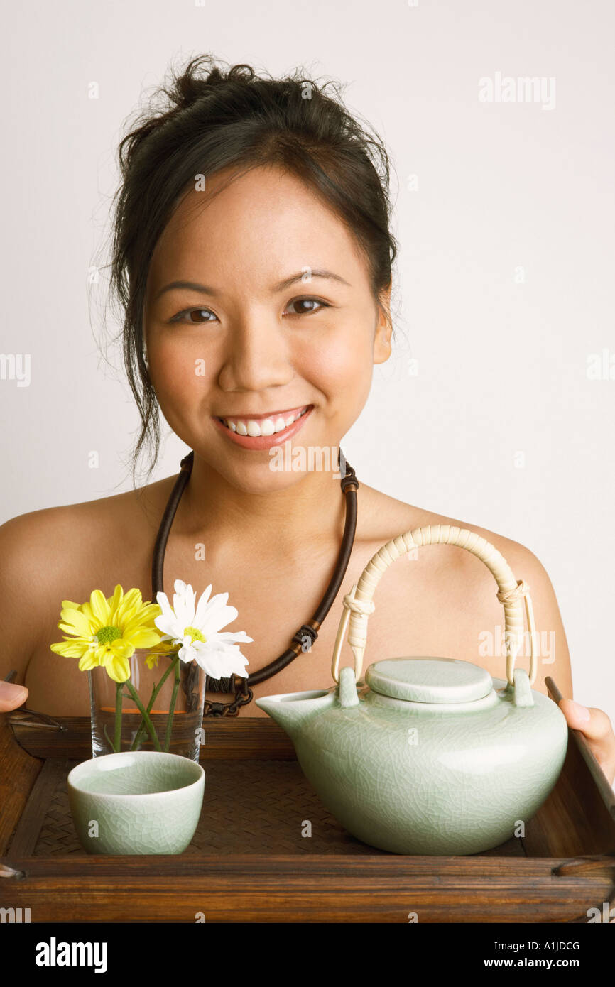 Portrait of a young woman holding a serving tray and smiling Stock ...