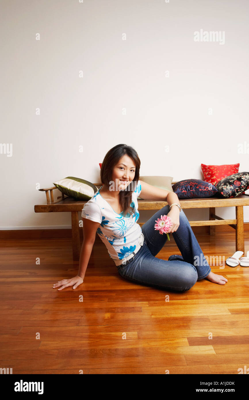 Portrait of a young woman sitting on the floor and smiling Stock Photo ...