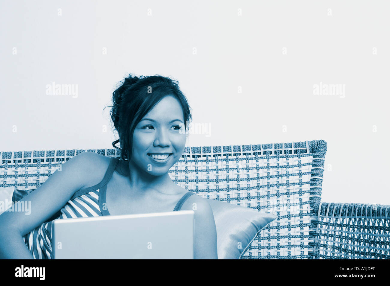 Young woman lying on a couch with a laptop Stock Photo - Alamy