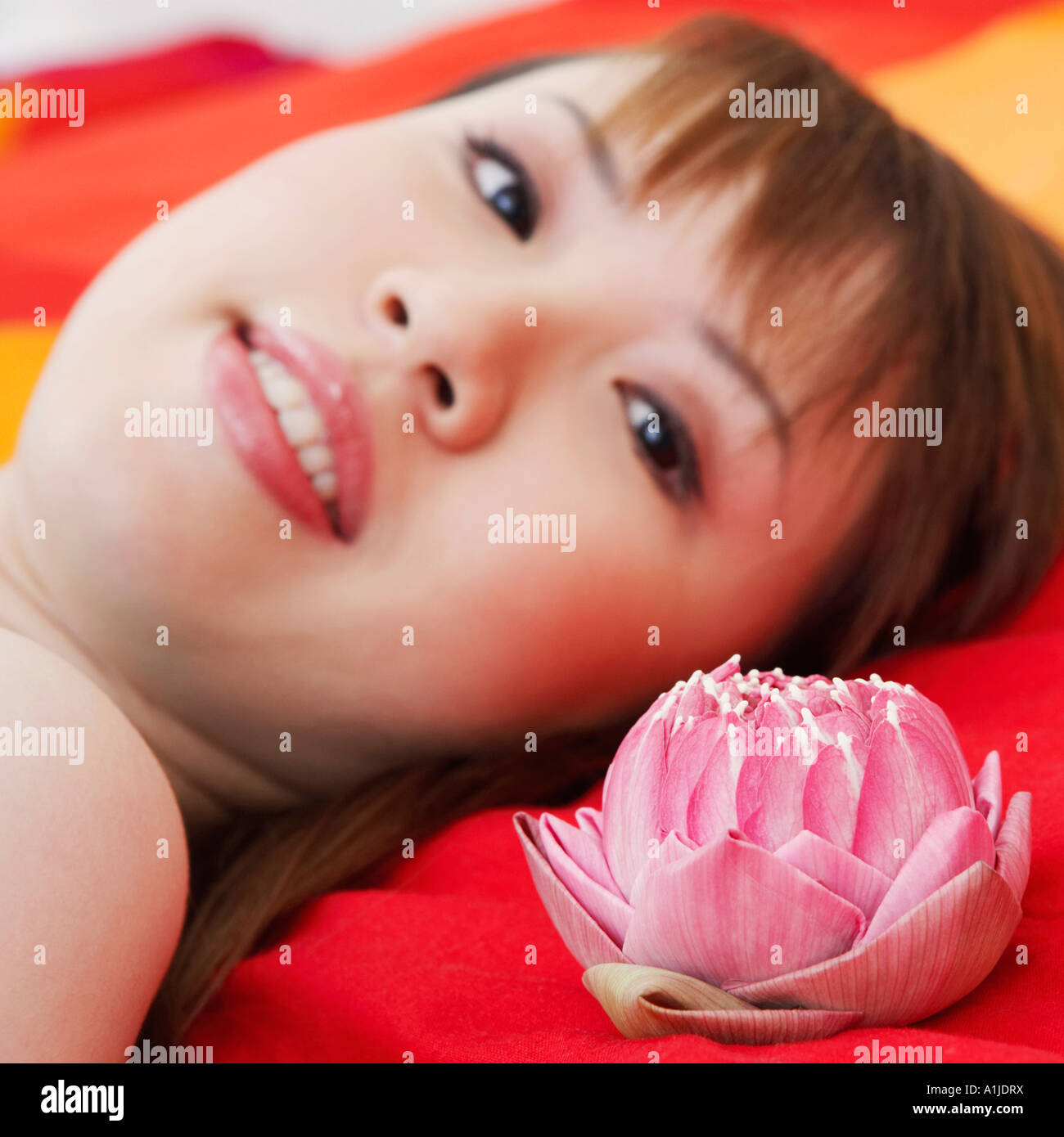 Portrait of a young woman lying on the bed and smiling Stock Photo - Alamy