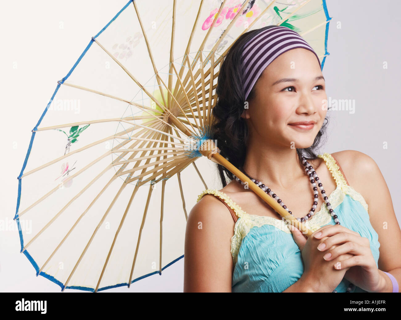 Close-up of a young woman holding a parasol and smiling Stock Photo