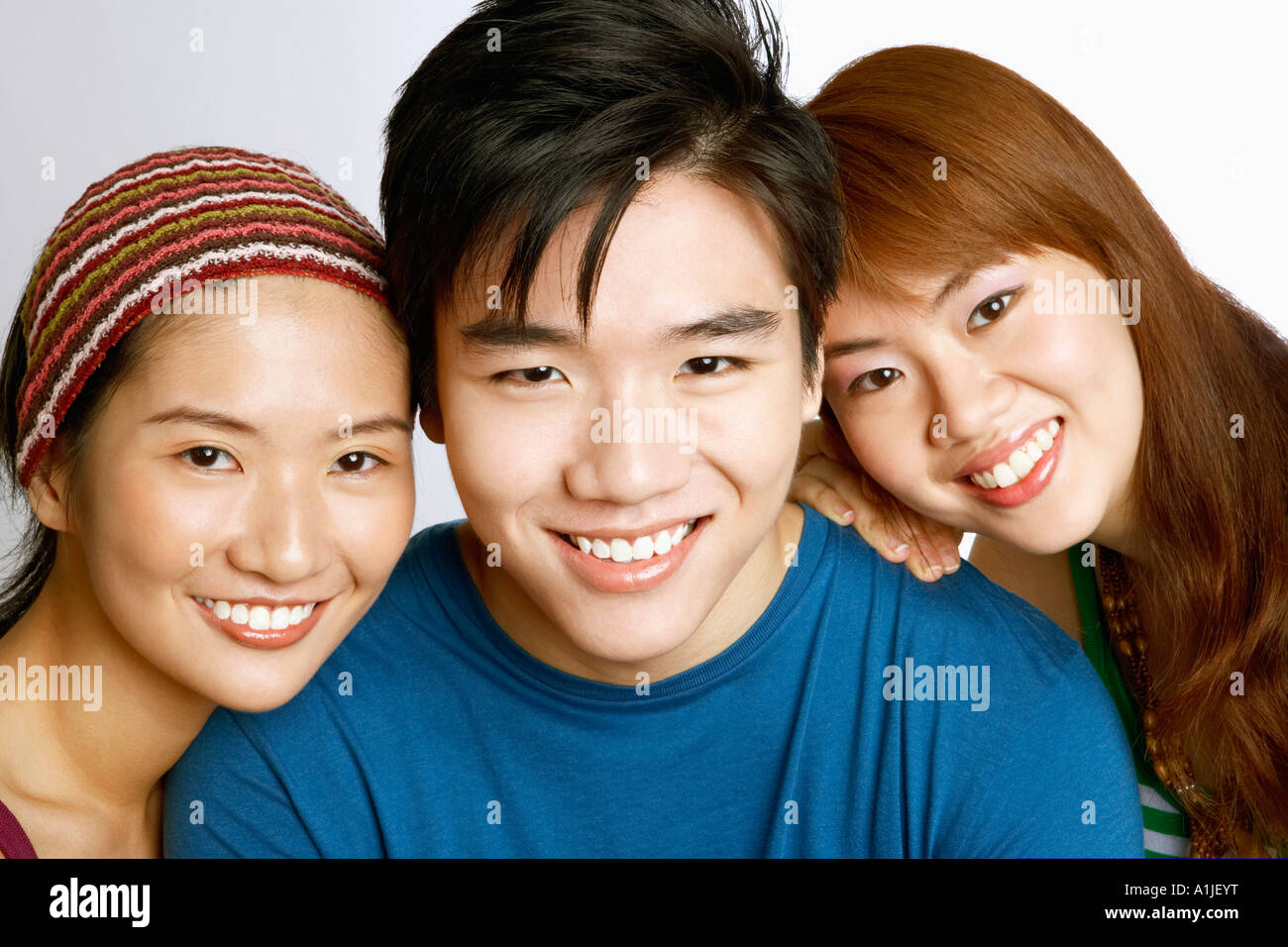 Portrait of a young man and two young women posing and smiling Stock ...