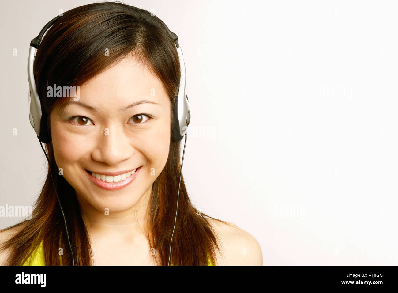 Portrait of a young woman listening to music and smiling Stock Photo