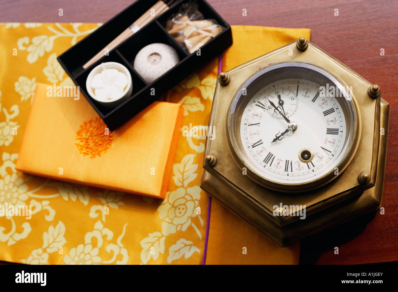 Closeup of candles and incenses in a box near a clock Stock Photo Alamy