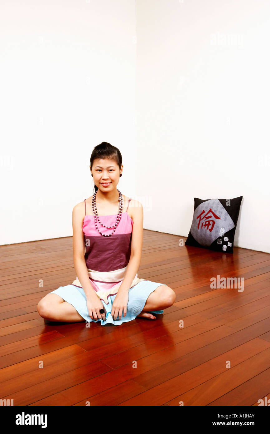Portrait of a young woman sitting on the floor and smiling Stock Photo ...