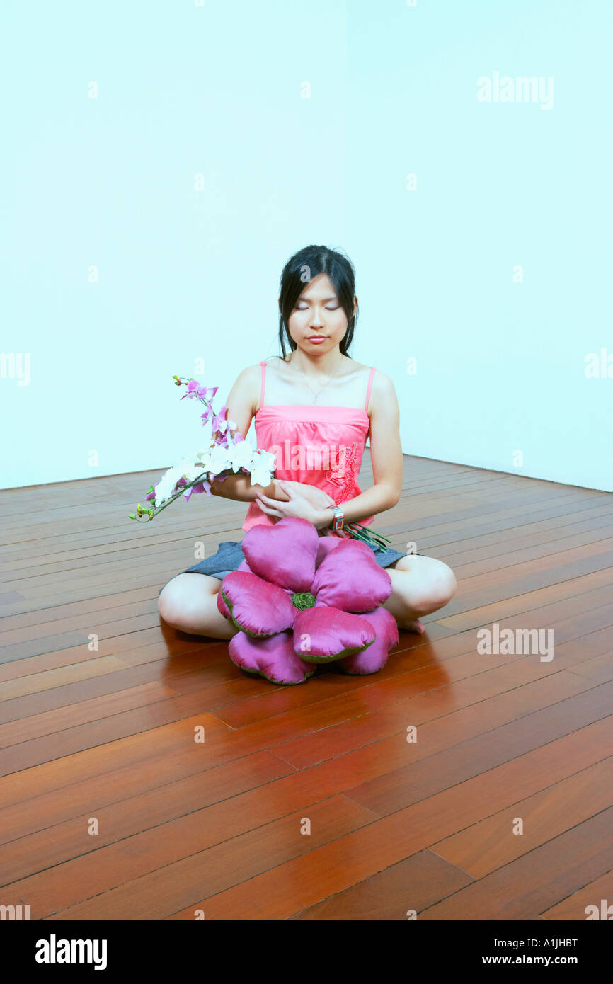 Young woman holding flowers with her eyes closed Stock Photo - Alamy