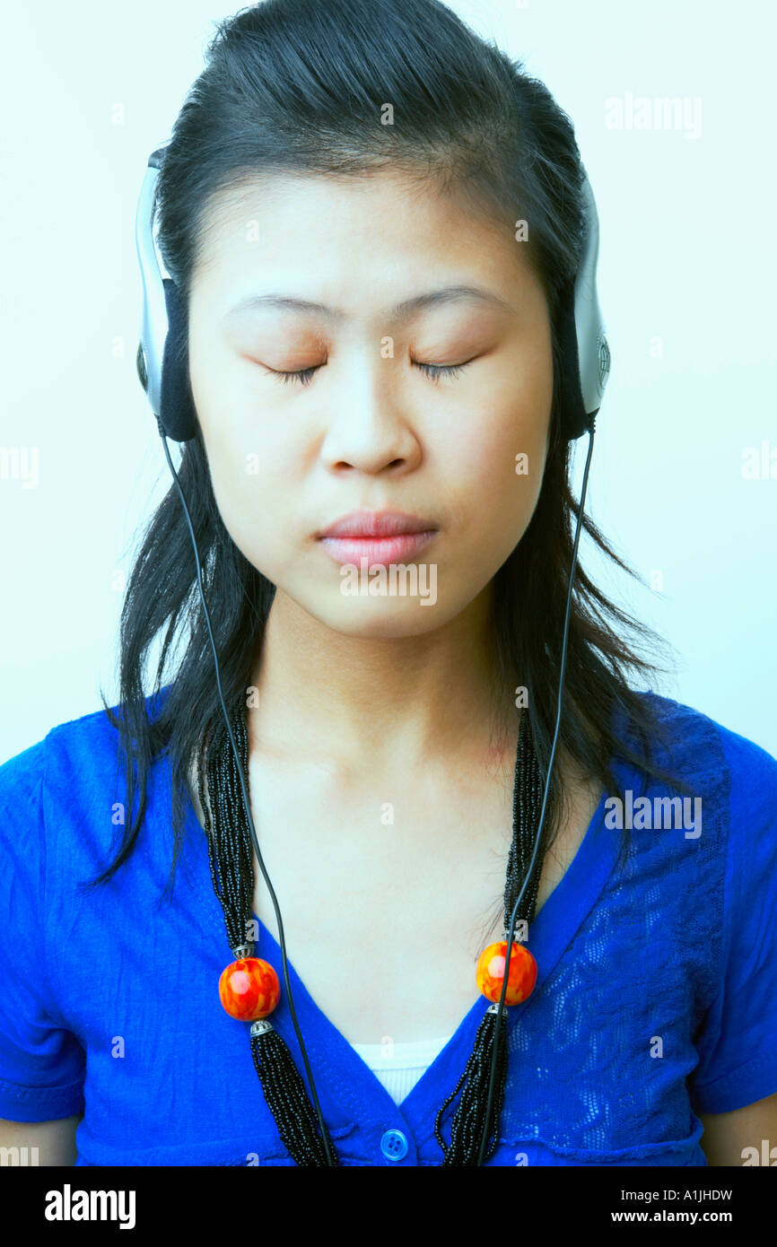 Close-up of a young woman wearing headphones and listening to music Stock Photo