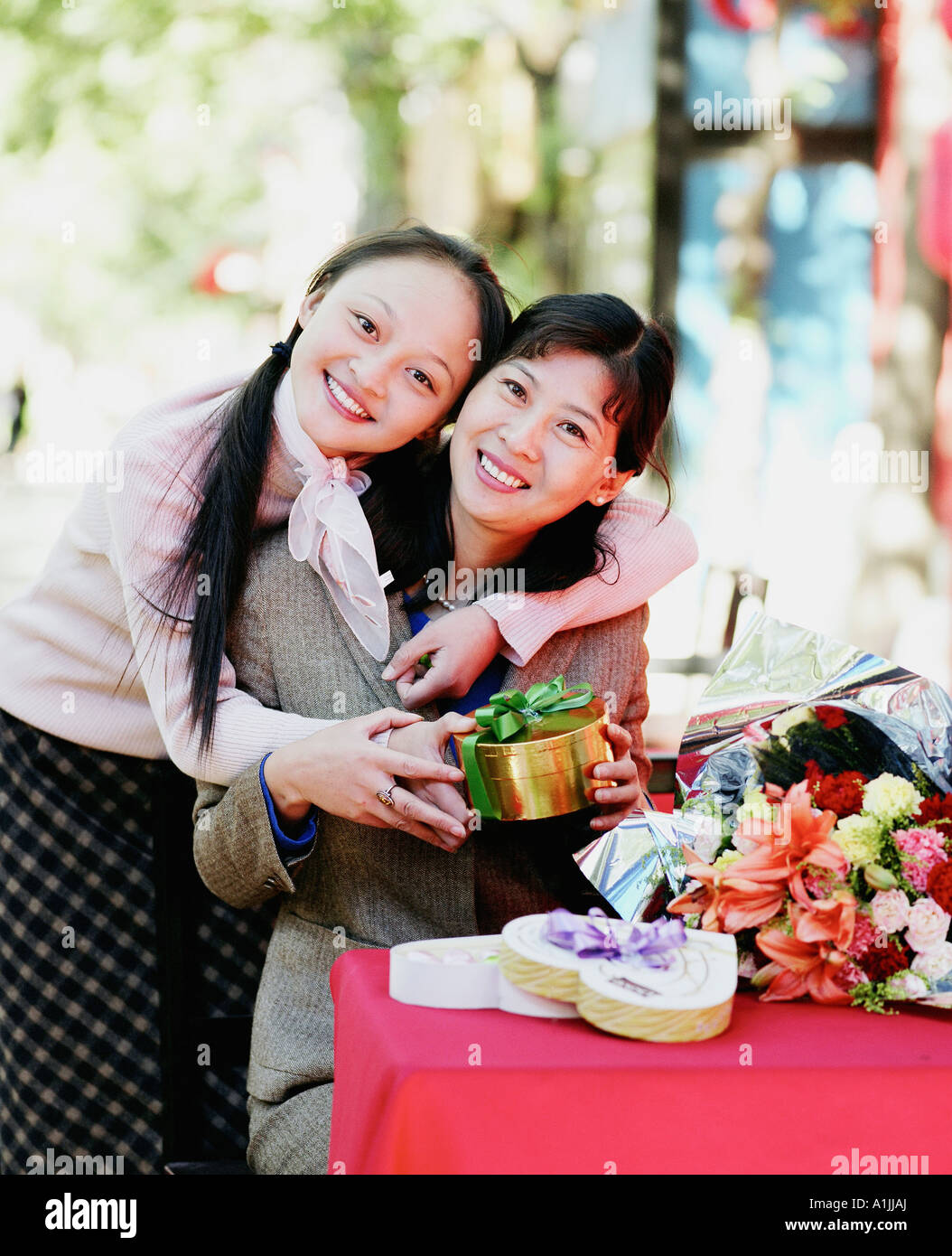 Portrait of two young women holding a gift and smiling Stock Photo