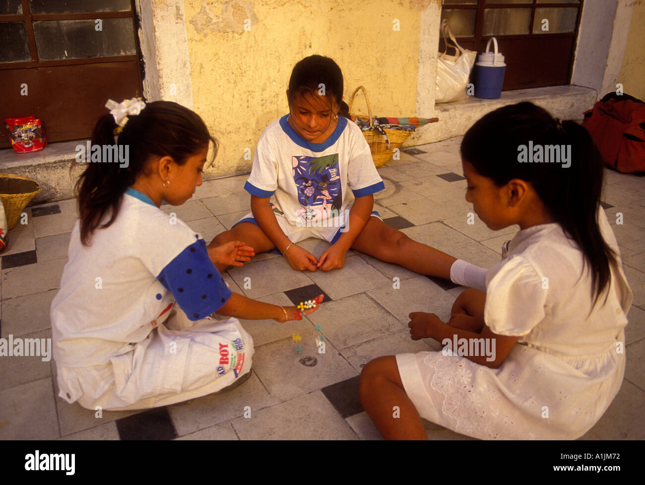 3, three, Mexican girls, schoolgirls, schoolchildren, playing jacks, city of Merida, Merida, Yucatan State, Yucatan Peninsula, Mexico Stock Photo