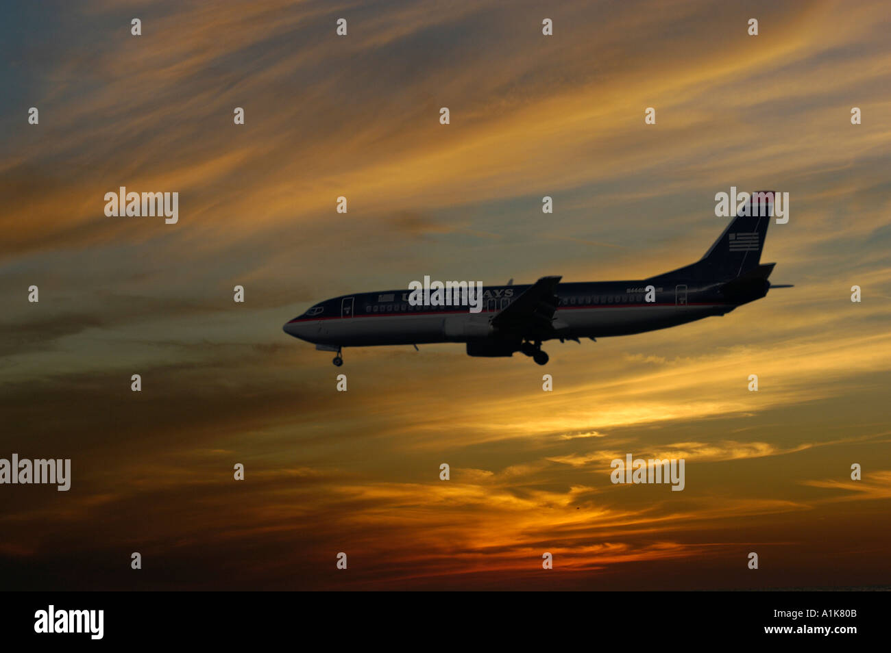 Silhouette of air plane into a setting sun in the evening as it prepares to land Stock Photo