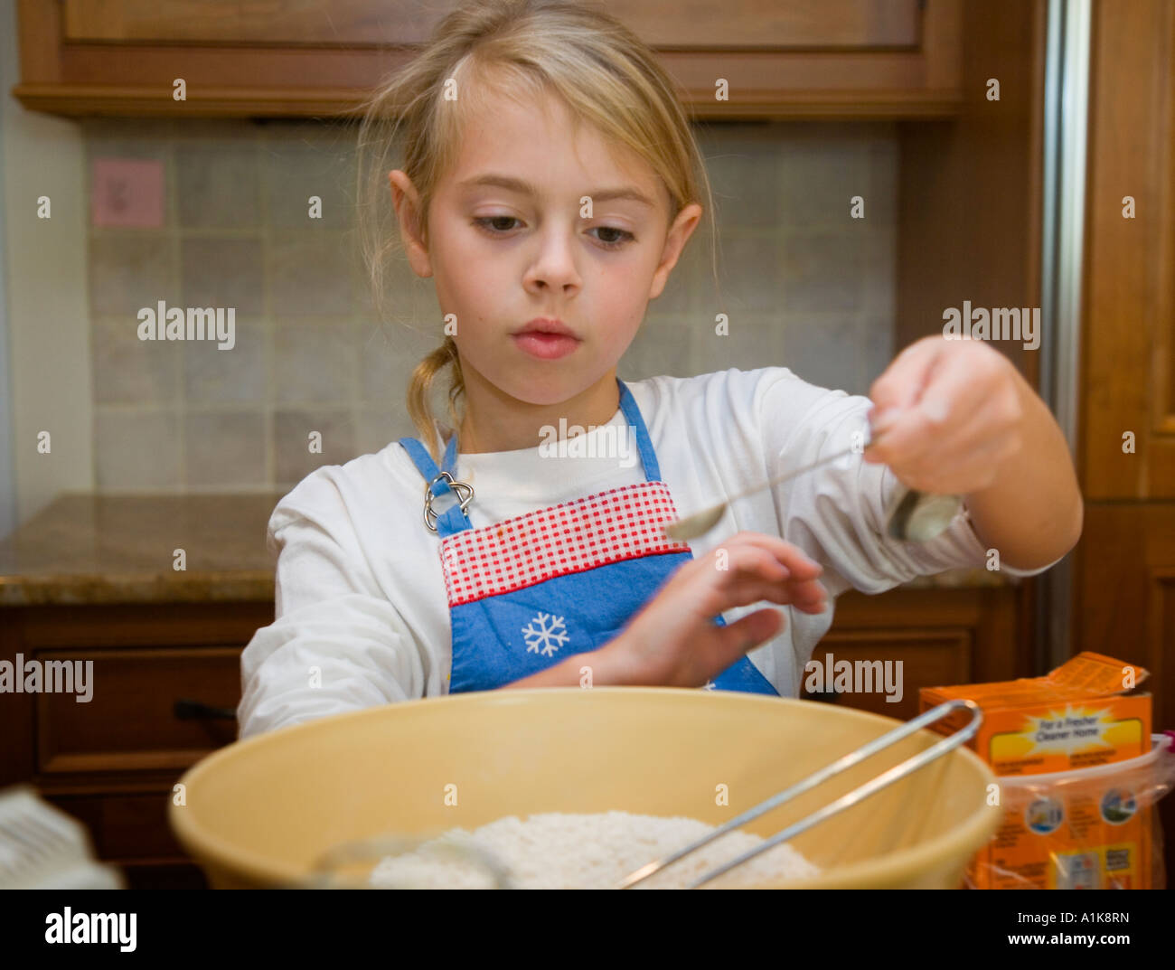 Child adding ingredients to a mixing bowl Stock Photo Alamy