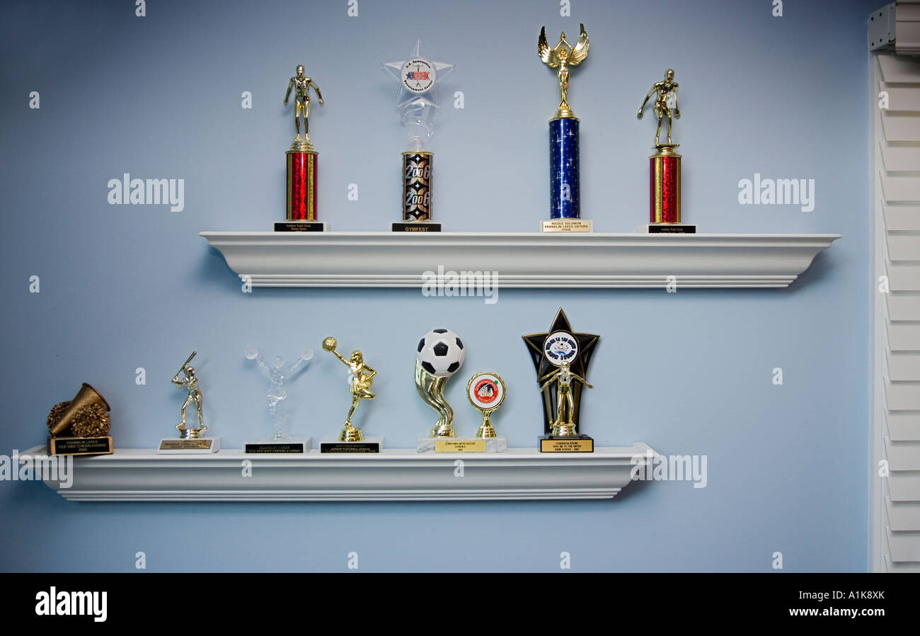 Trophies displayed on a shelf in a child's room Stock Photo