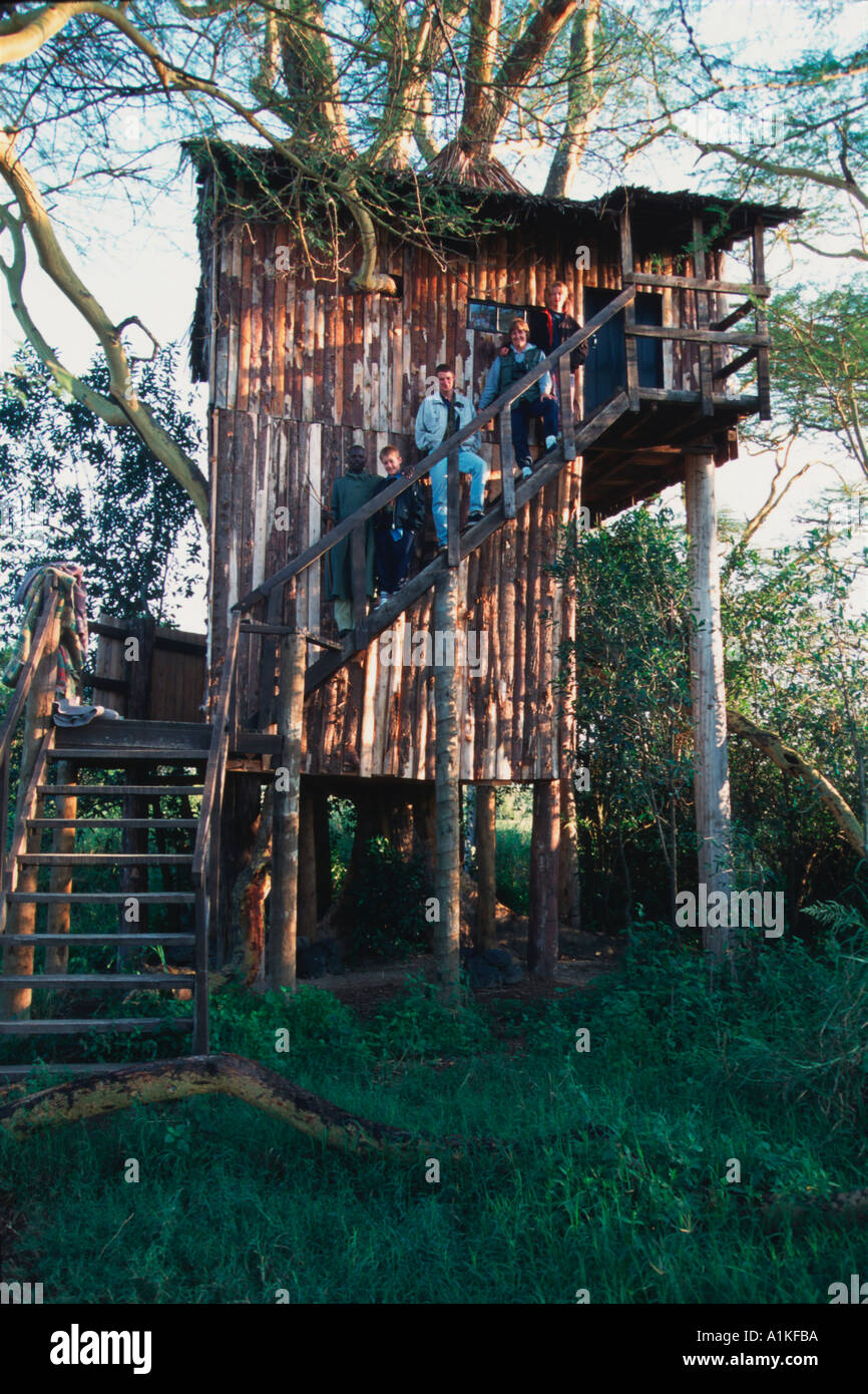 Family on safari outside tree house Stock Photo