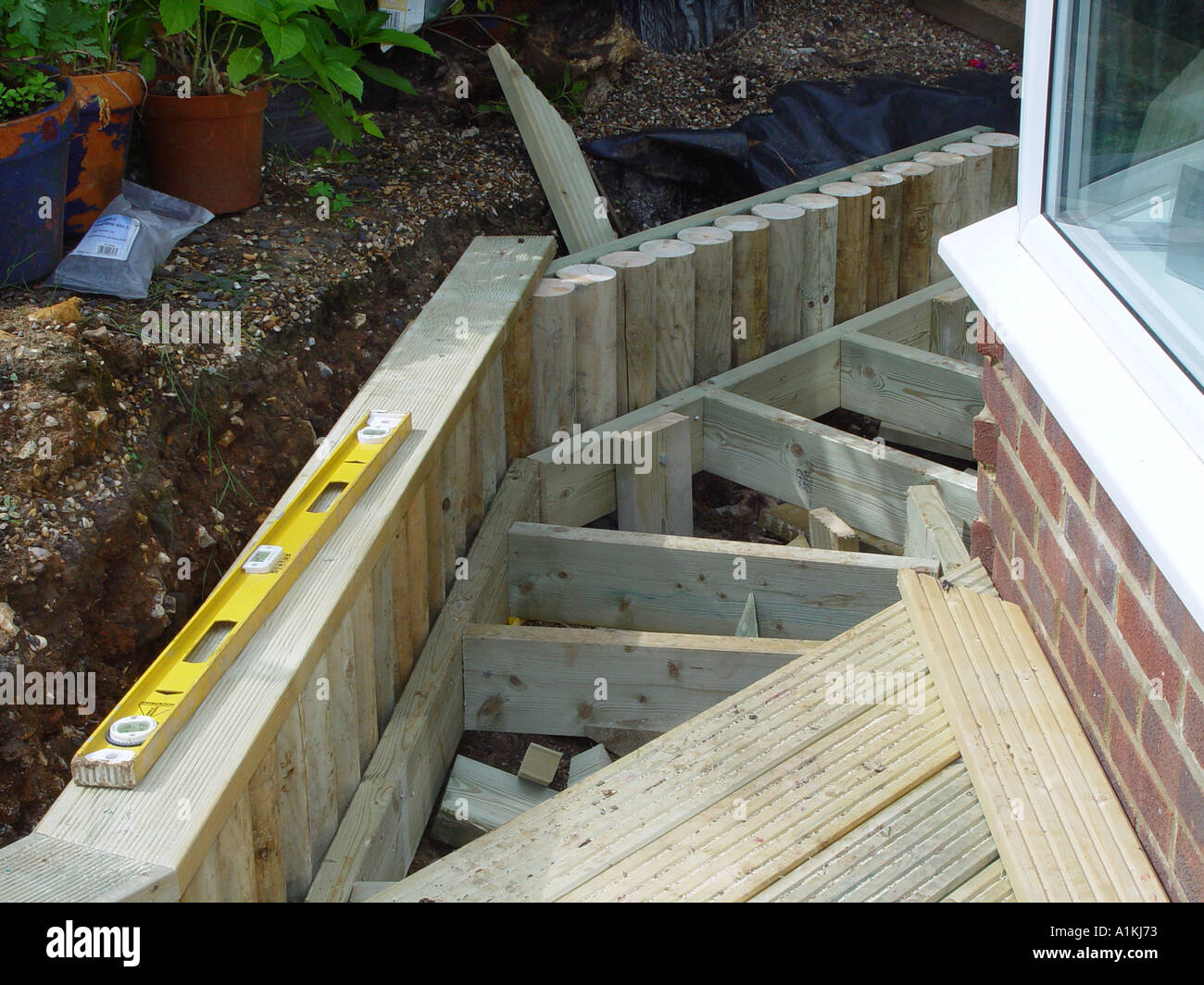 deck construction showing timber log retaining wall in the decking