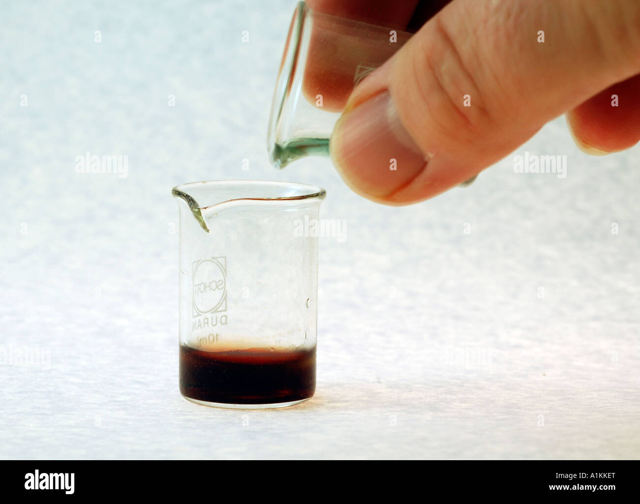 pouring Chemicals into a beaker Stock Photo