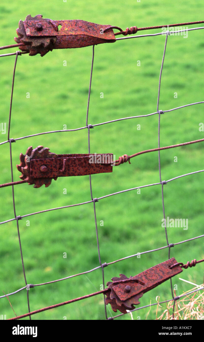 Rusty metal fence tensioner on wire fence Stock Photo