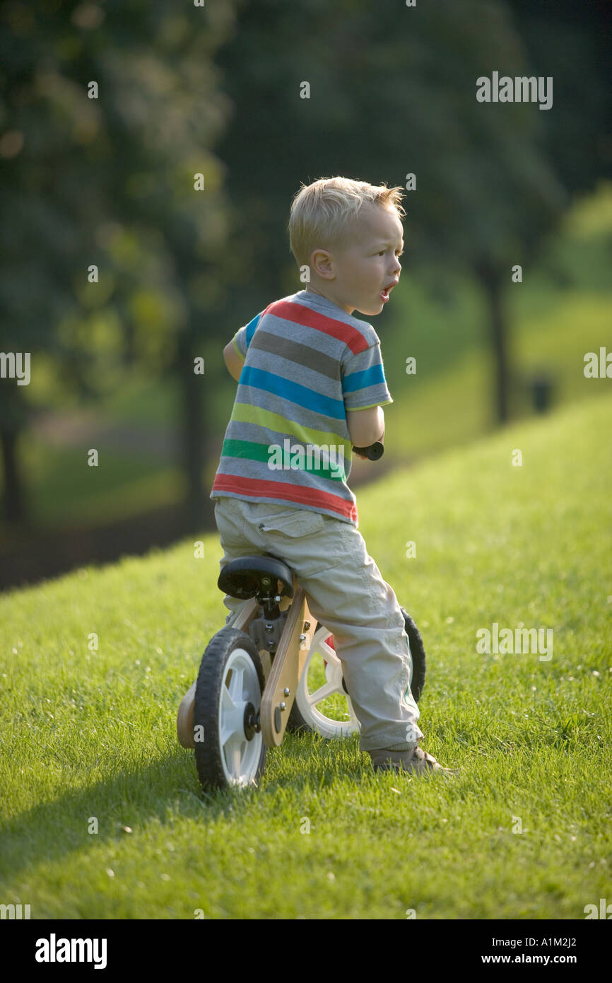 Little boy sitting on a bike with a indignant expression Stock Photo