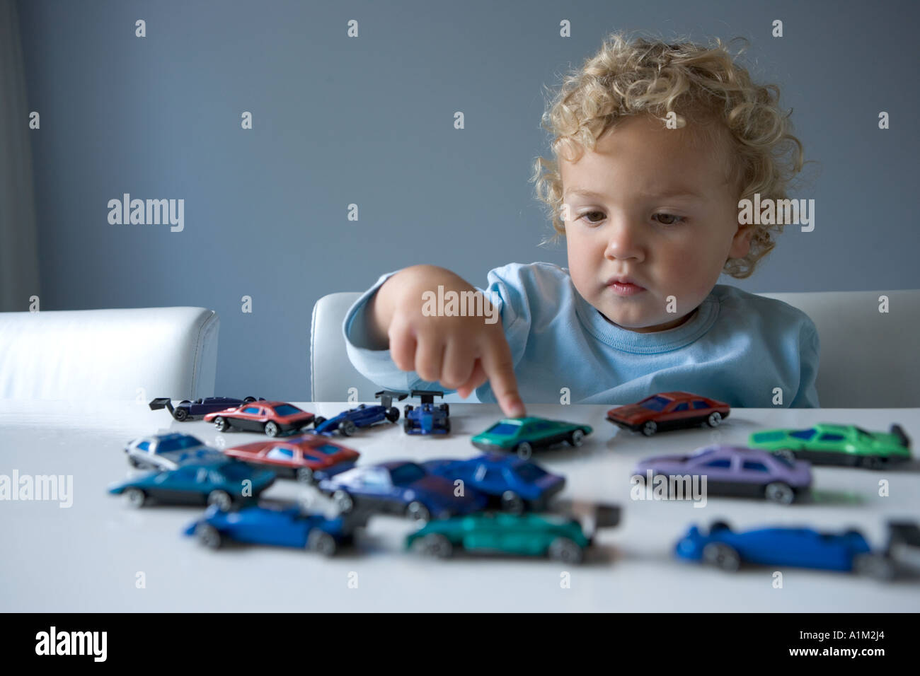 Little boy playing with toy cars Stock Photo - Alamy