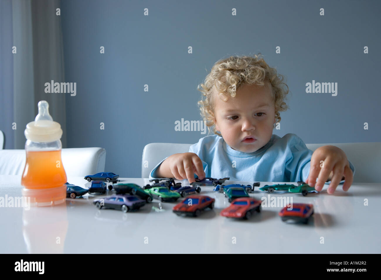 Little boy playing with toy cars Stock Photo - Alamy