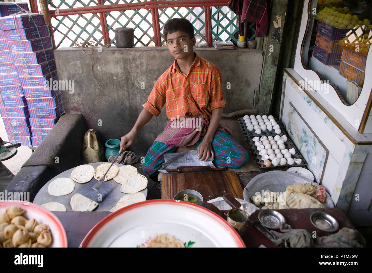 Boy frying bread at road side restaurant in Sonargoan Bangladesh Stock
