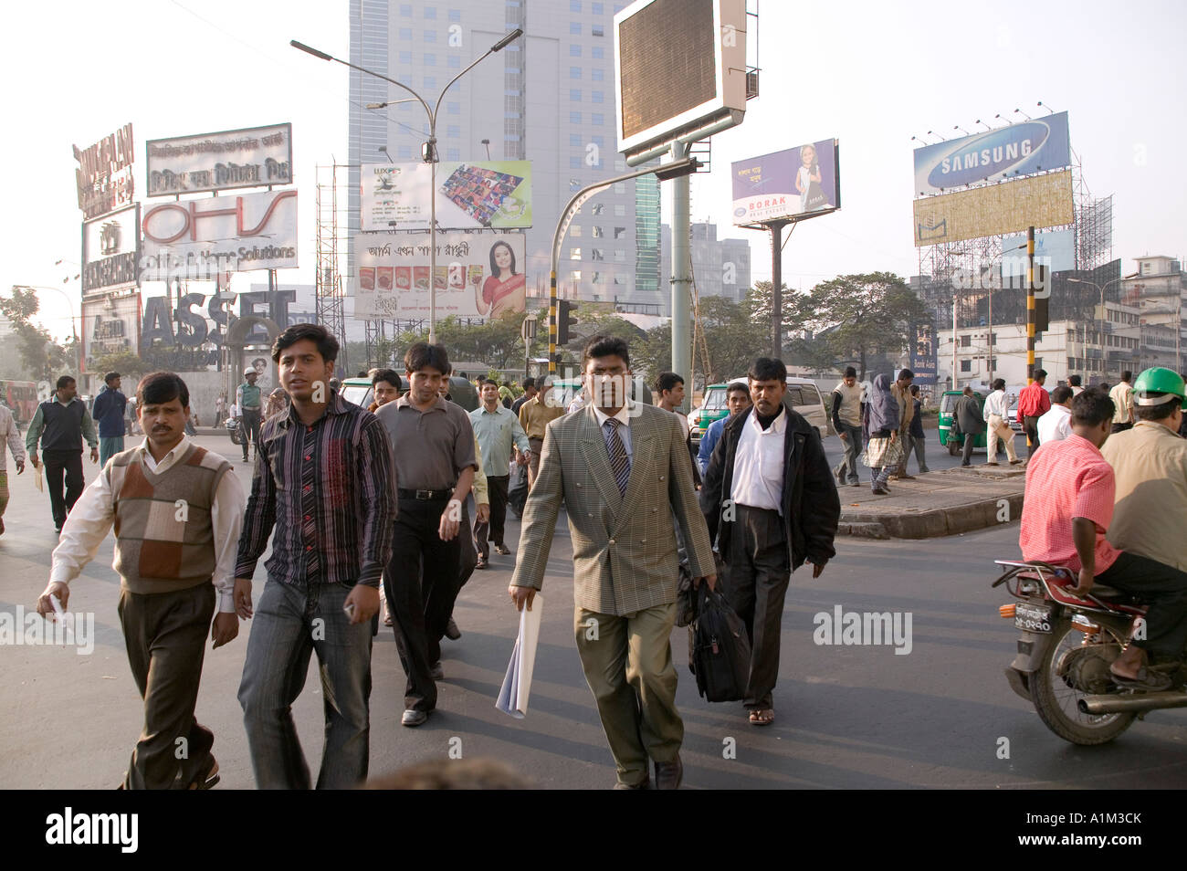 Office workers walking across the street in Dhaka Bangladesh Stock