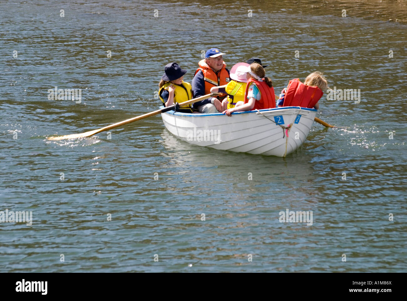 Family in rowing boat wearing life jackets Stock Photo Alamy