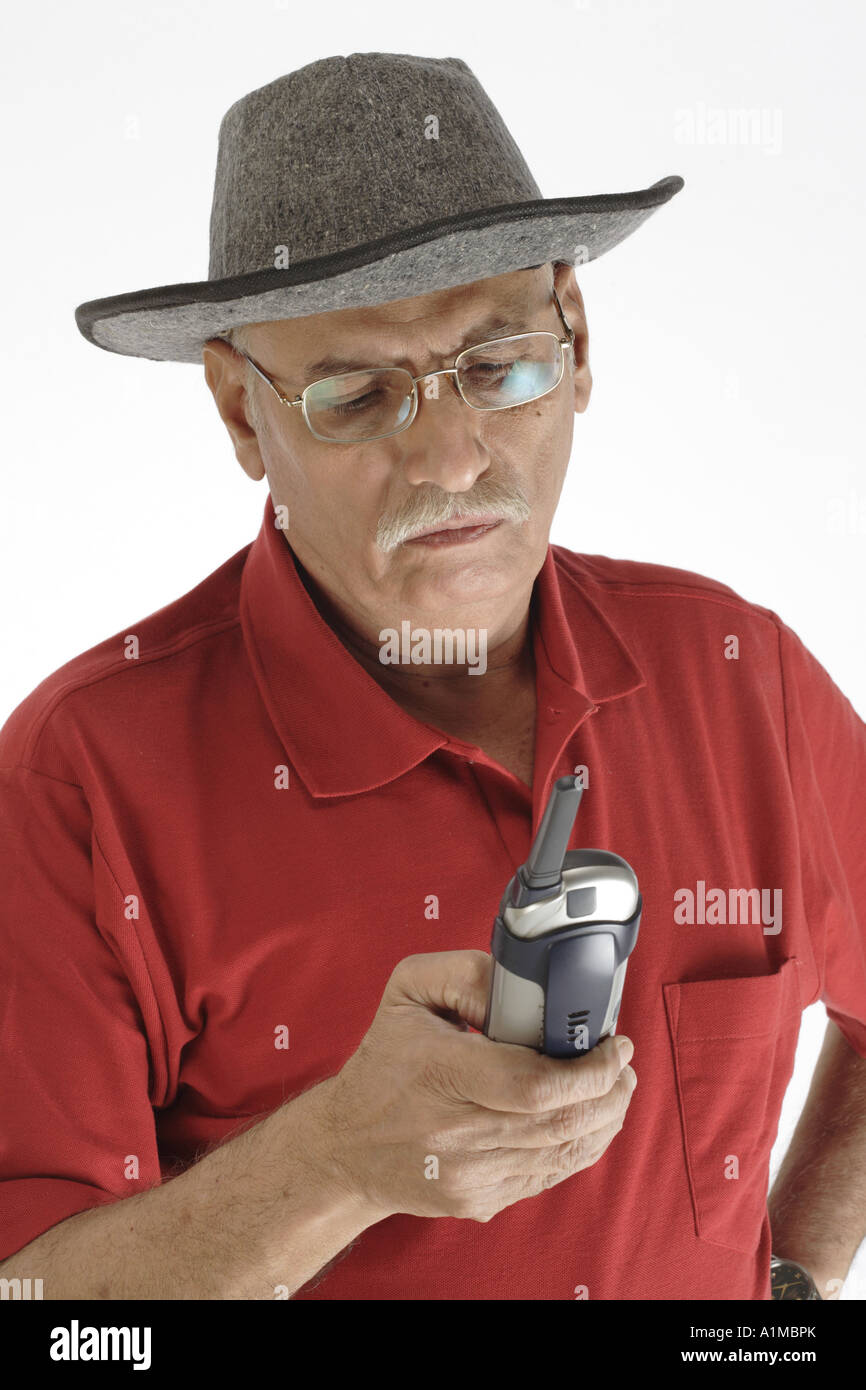 Senior citizen wearing hat dialing number on mobile phone Stock Photo