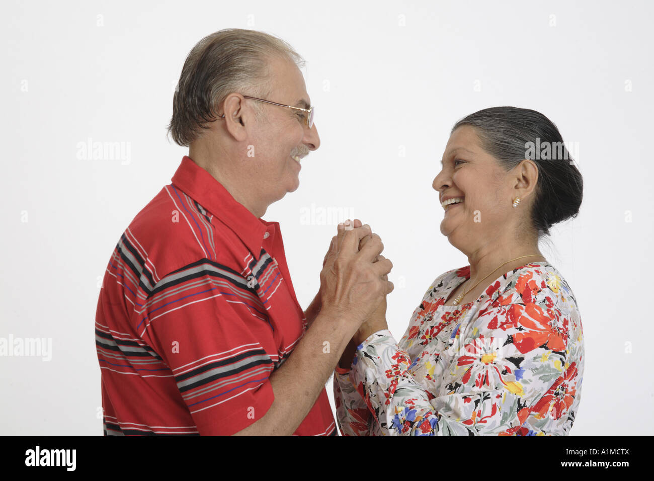 Loving Indian senior citizen couple standing holding hands Stock Photo