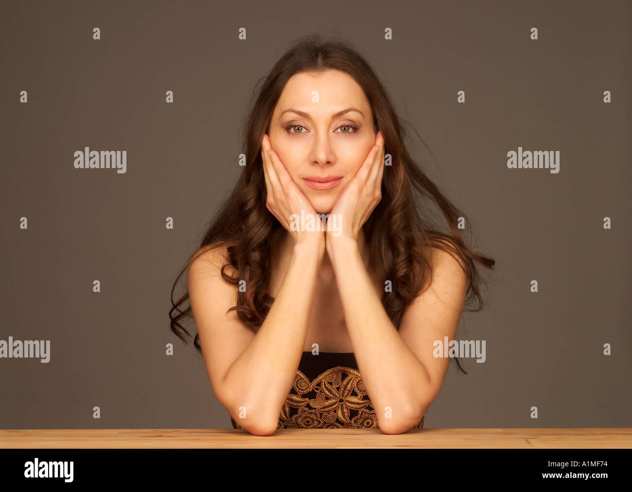MR Beautiful woman leaning her face on her hands Stock Photo - Alamy